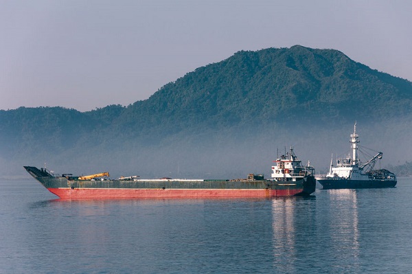 Cargo Ships On The Sea With Mountain On Background